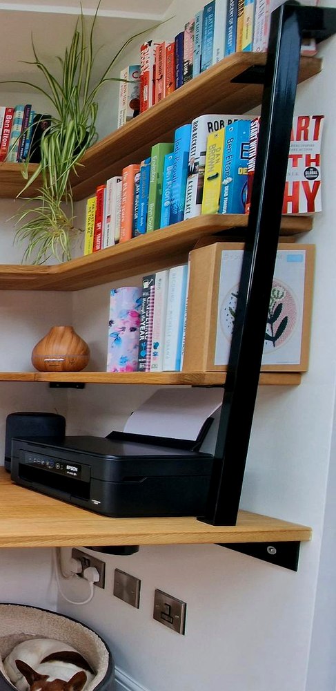 Graduated solid oak floating shelves on hidden fixings and a black steel support pole
